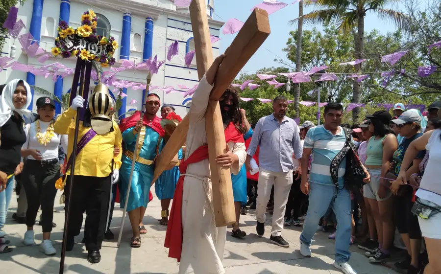 Mayordomos adornan la cruz para su veneración antes del Viacrucis.