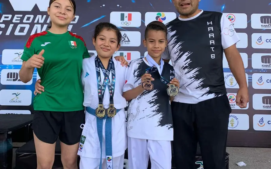El entrenador Héctor Cruz con los tres medallistas