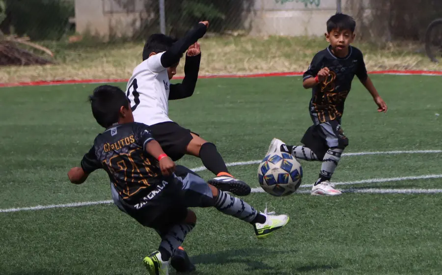 Equipos de futbol infantil compiten durante un partido de la liga de barrios para definir quiénes avanzarán a la ronda de semifinales.