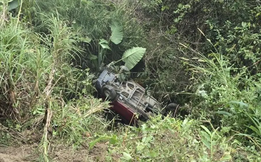 El vehículo accidentado yace en el fondo de un barranco, escena del fatal percance donde murieron un agente municipal y una mujer.
