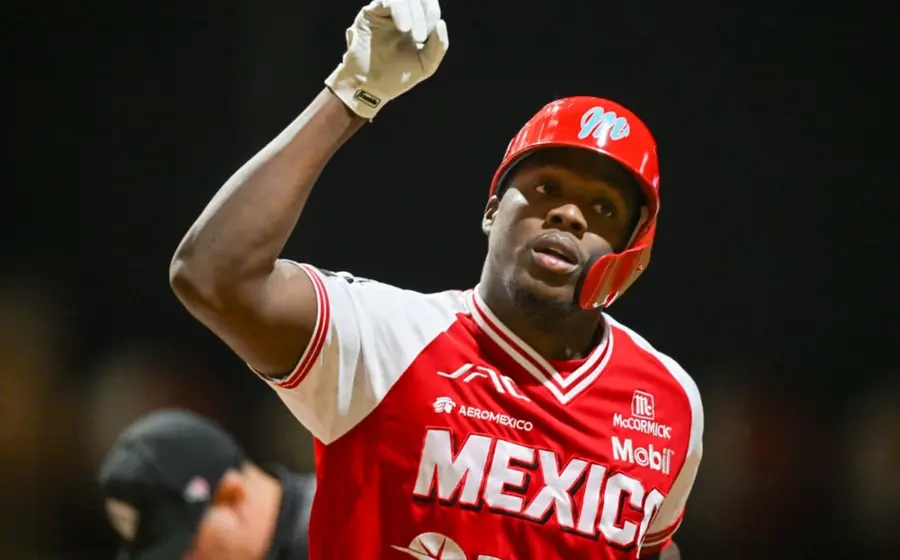 El beisbolista Aristides Aquino, nuevo refuerzo estelar, se prepara en el campo de juego para conectar un potente batazo.