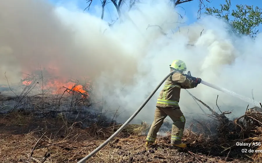 Elementos del Heroico Cuerpo de Bomberos de Juchitán sofocando un incendio menor ocasionado durante los festejos de Año Nuevo en la ciudad.