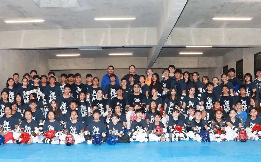 Más de 70 artemarcialistas de taekwondo posan juntos durante el campamento de alto voltaje, un evento de entrenamiento intensivo.