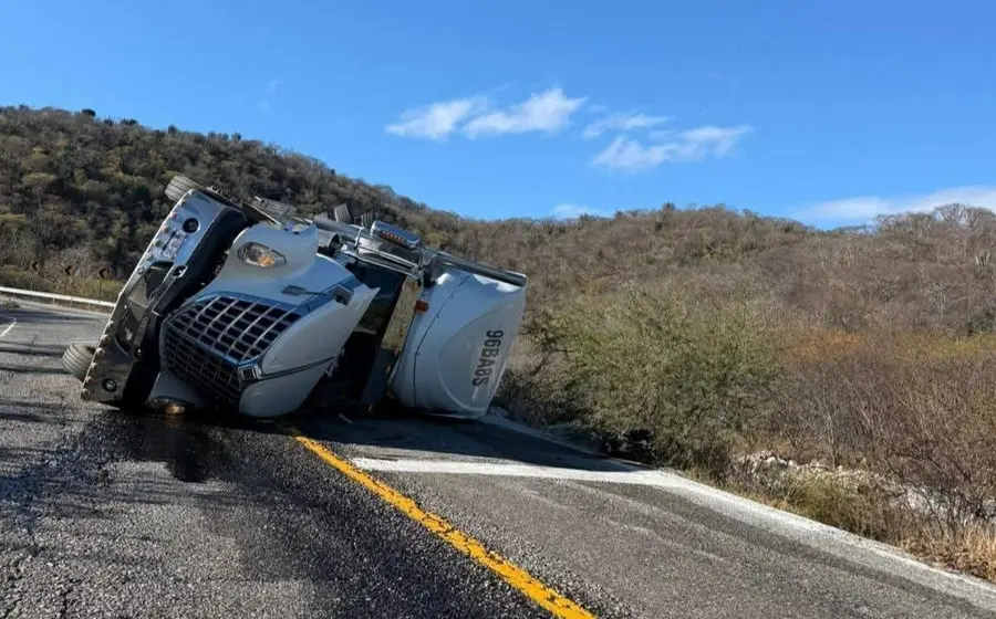 Un tractocamión volcado a un costado de la carretera tras el fatal accidente en el que el conductor perdió la vida.