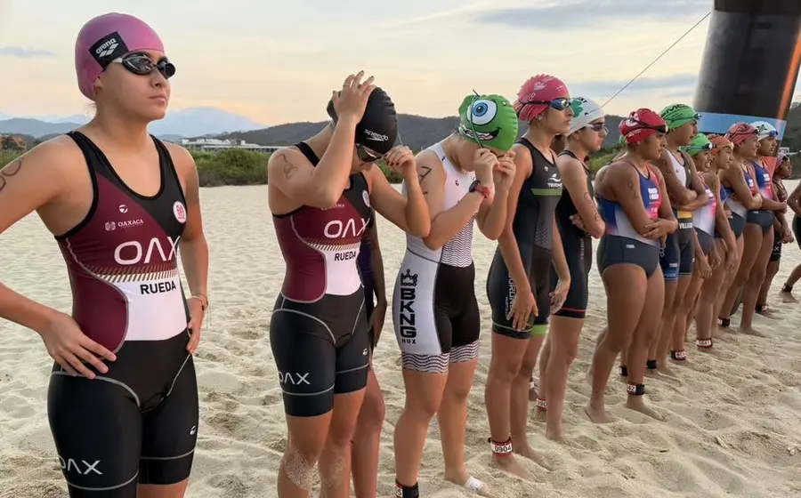 Jóvenes atletas se preparan en la línea de salida para la competencia de triatlón de la Olimpiada Estatal, buscando su pase a Veracruz.