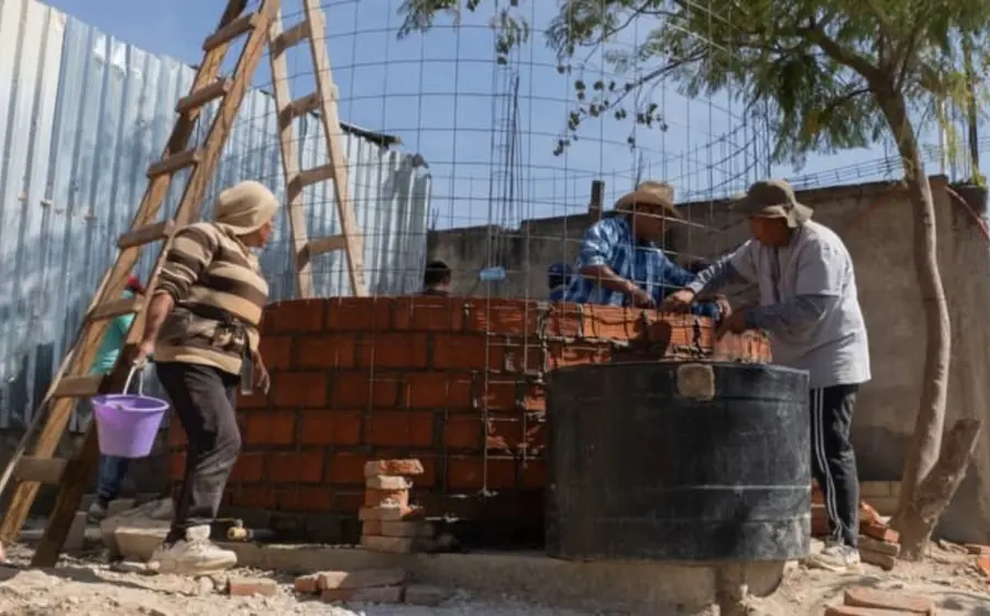 Miembros de la organización Flor y Canto trabajan en la construcción de un sistema de captación de agua de lluvia en una escuela de Zaachila.