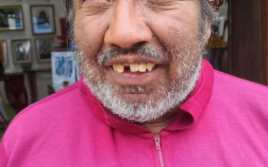 Un hombre, figura familiar para los habitantes del centro de la ciudad, sonríe a la cámara iluminando la calle con su gesto amable.