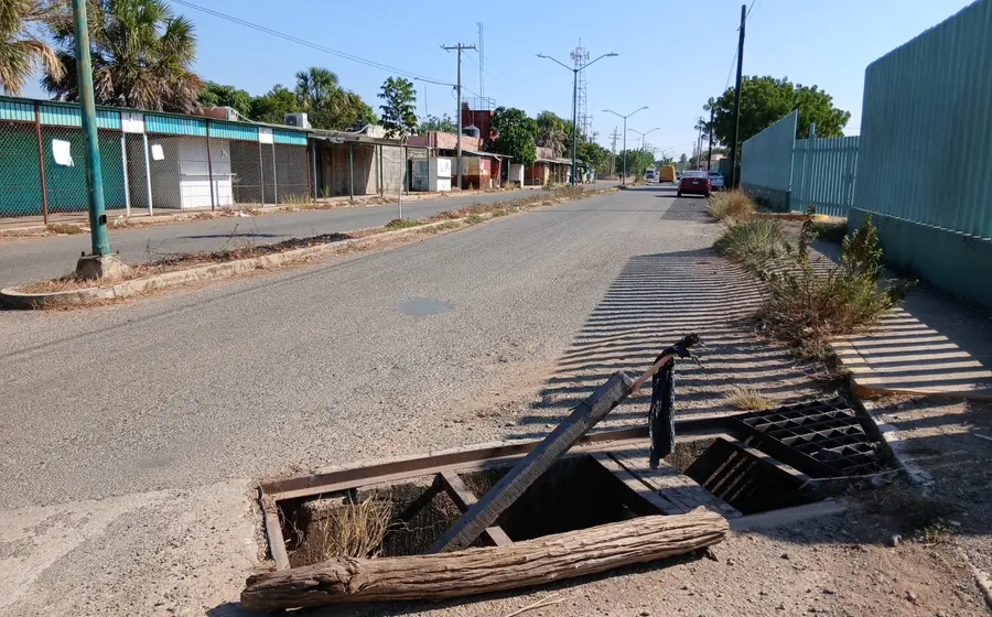 Un tramo de la Avenida Universidad en Tehuantepec con enormes baches que parecen cráteres, mostrando las pésimas condiciones de la vialidad.