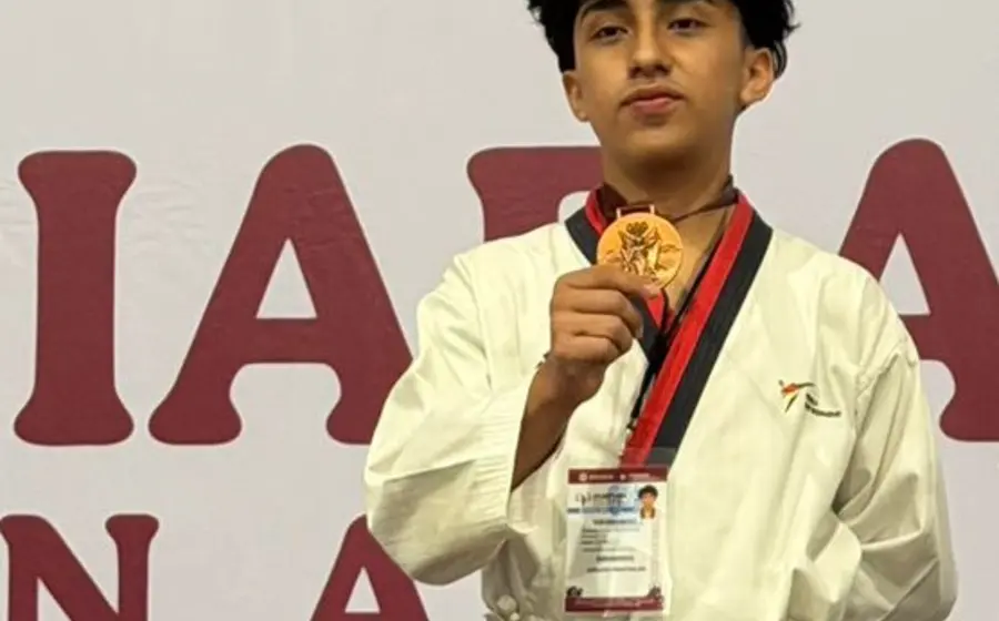 El atleta Miguel Joaquín López Barenca posa en el podio de ganadores durante la premiación de la etapa estatal de taekwondo.
