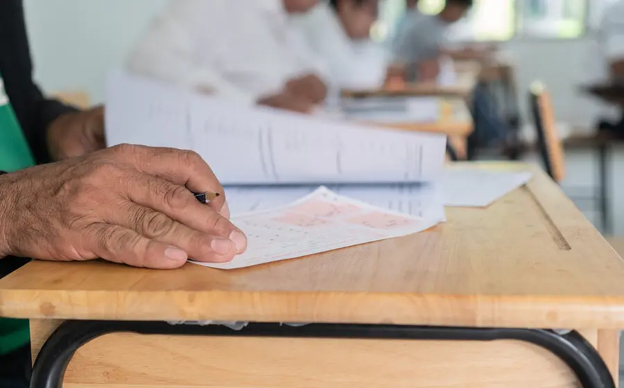 Un grupo de adultos en un salón de clases en Oaxaca participando en un programa educativo para el que se buscan voluntarios.