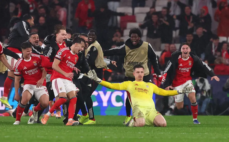 El equipo de Benfica celebra su histórica remontada contra el Real Madrid, un resultado que deja al equipo merengue fuera del Top 8.