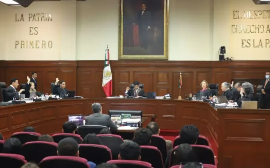 Un mazo de juez sobre libros de leyes, representando la sentencia de la SCJN sobre el pago retroactivo de la pensión alimenticia a los hijos.