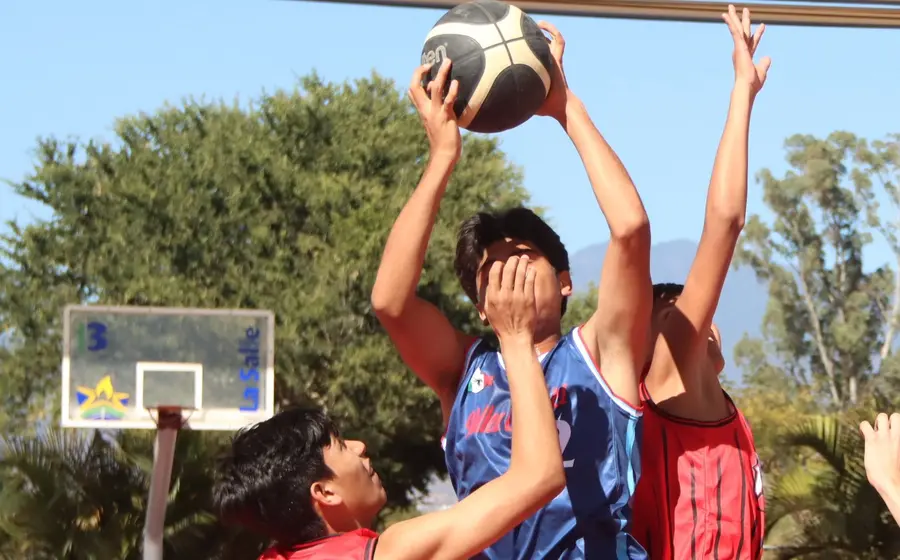 Jóvenes jugadores participan en el torneo relámpago de basquetbol que da inicio a la festividad anual en San Antonio Huitepec.