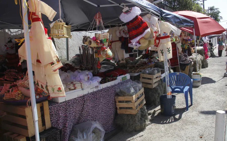 Vendedores en un mercado de Tehuantepec exhiben vestimentas tradicionales de diversos modelos para la celebración del Día de la Candelaria.
