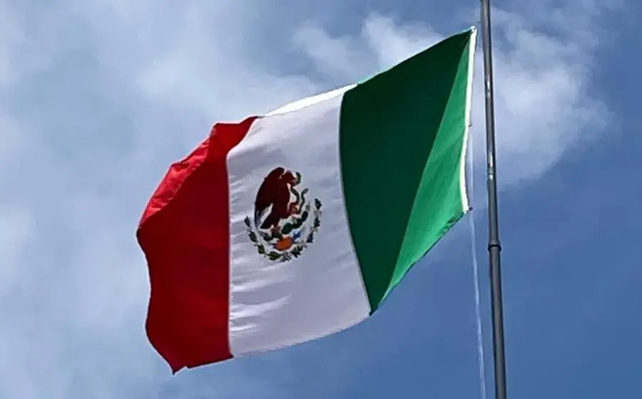 La Bandera Nacional de México, también conocida como el lábaro patrio, ondeando en conmemoración de su día oficial, un símbolo de la historia mexicana.