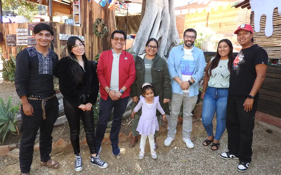 Óscar y Lila, al centro de la imagen, celebran su cumpleaños sonriendo felices en compañía de sus amigos y familiares durante el festejo.