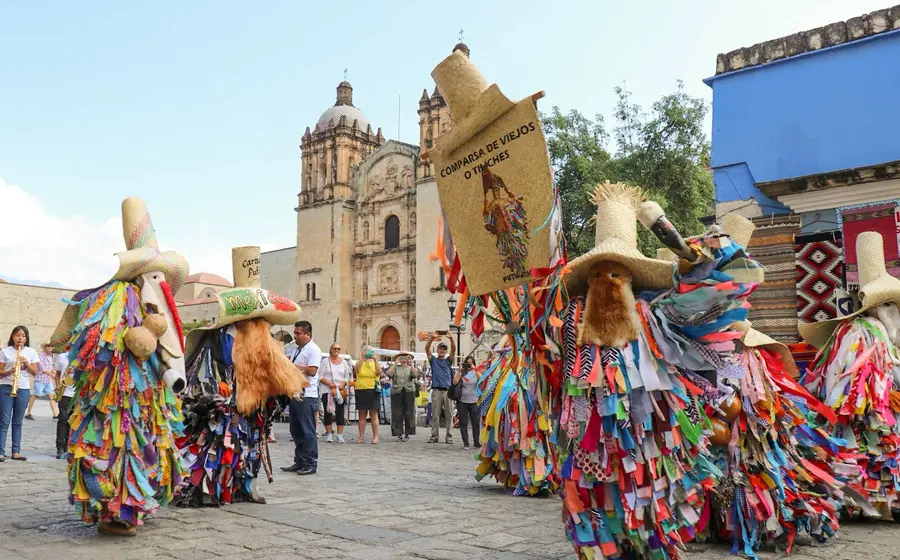 Un contingente con trajes coloridos desfila por las calles del Centro Histórico de Oaxaca durante la Muestra de Carnavales anunciada para 2026.