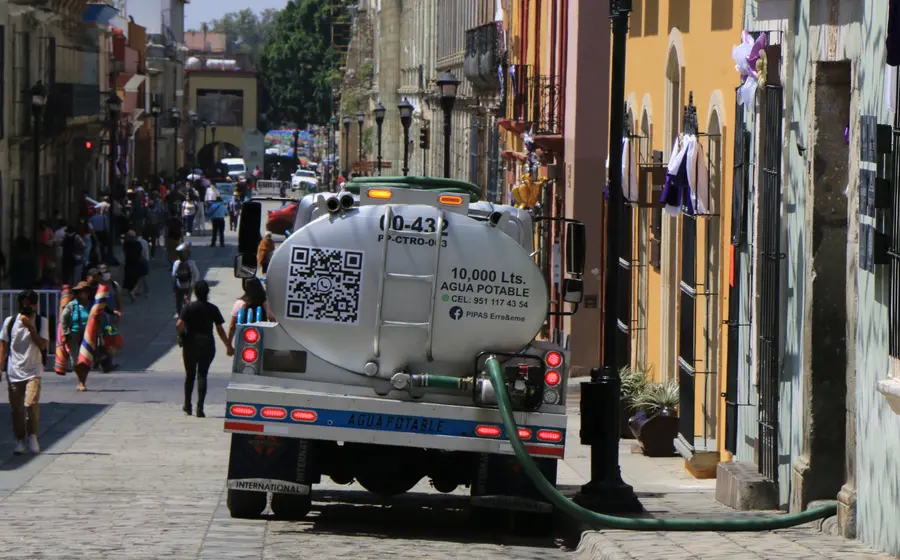 Una pipa de agua abastece a vecinos durante el estiaje, reflejando el aumento de precios por la escasez de agua en la ciudad.