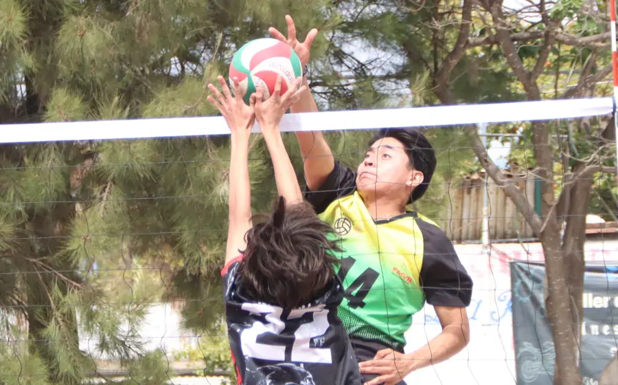 Jugadores de voleibol compiten durante el torneo comunitario celebrado en Manialtepec, un evento que fomenta la convivencia entre los participantes.