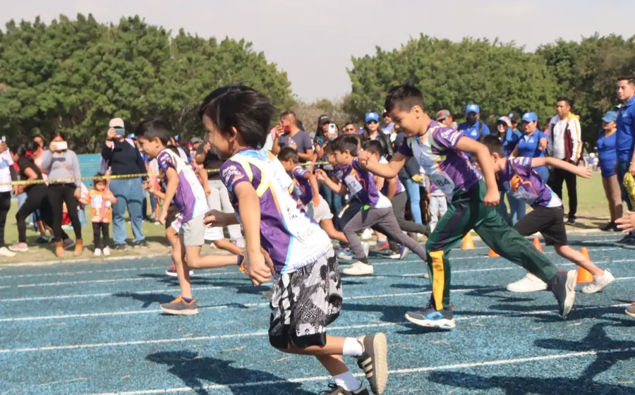 Jóvenes atletas compiten con gran emoción en la pista durante la etapa regional de los Juegos Deportivos Infantiles.