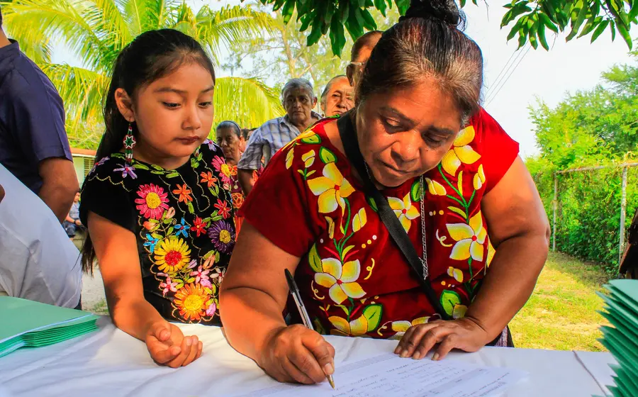 La indígena chinanteca de Tuxtepec, Imelda Conde Hernández, sostiene el reconocimiento que le fue entregado por su trayectoria y labor comunitaria.