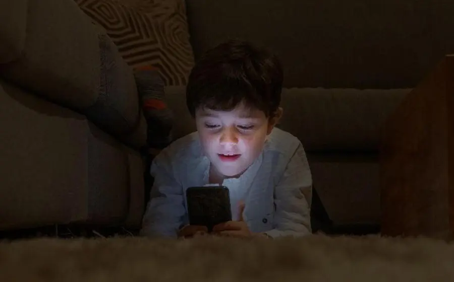 Un niño usando una tableta, ilustrando los riesgos de la infancia hiperconectada y la recomendación de expertos sobre horarios sin dispositivos para el aprendizaje.