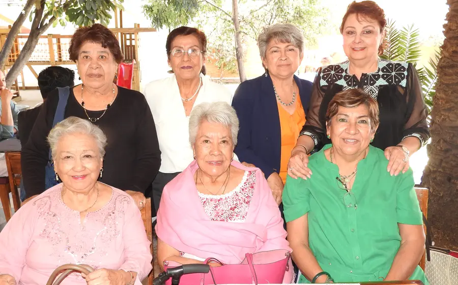 Jose Núñez, sentada al centro, celebra su cumpleaños sonriendo en compañía de su grupo de amigas durante una reunión especial.