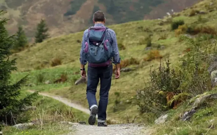 Una persona caminando al aire libre, lo cual es recomendado por expertos para cumplir la meta de 8 mil a 10 mil pasos diarios.