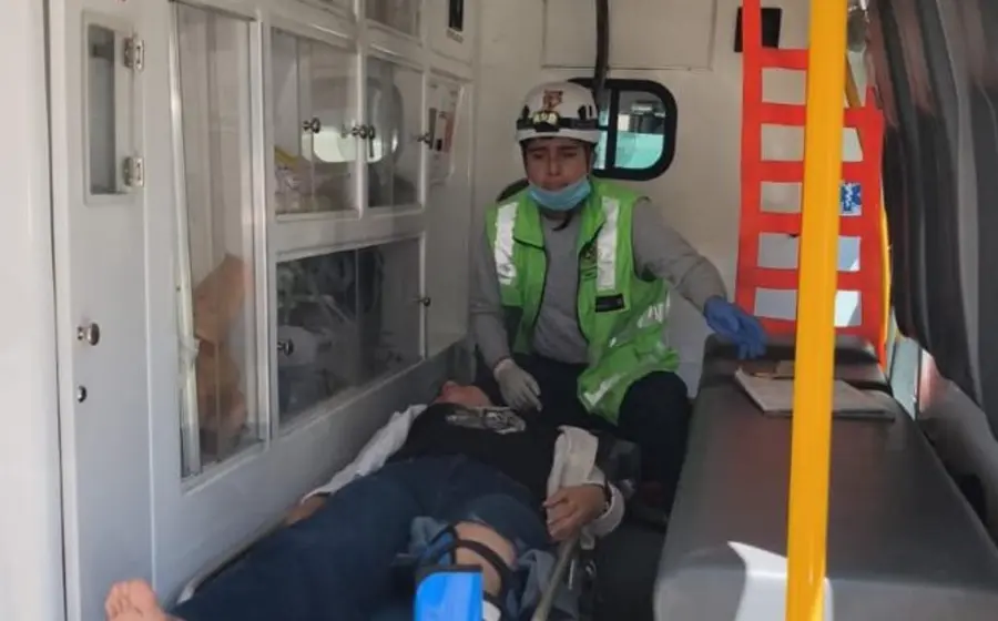La mujer que resultó lesionada tras un accidente de motocicleta es trasladada en una camilla por paramédicos para recibir atención hospitalaria.