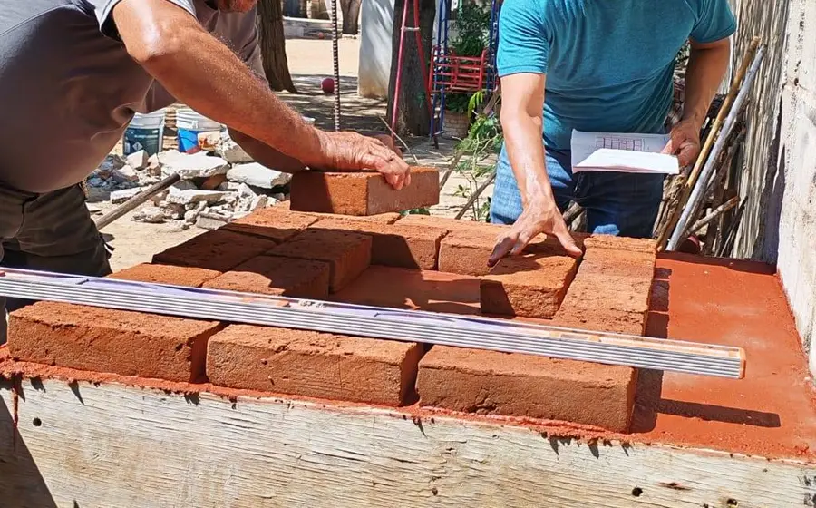 Participantes de un taller comunitario trabajan en el diseño y la fabricación de estufas ecológicas de acuerdo a sus necesidades específicas.