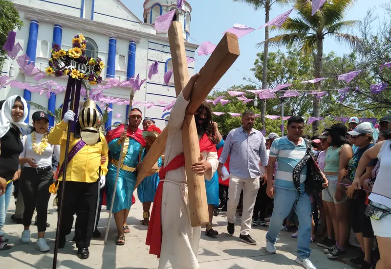 Mayordomos adornan la cruz para su veneración antes del Viacrucis.