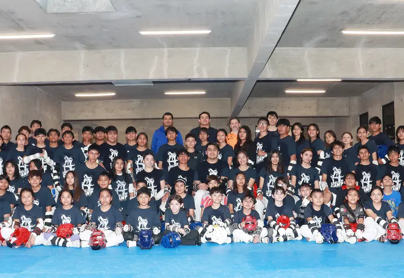 Más de 70 artemarcialistas de taekwondo posan juntos durante el campamento de alto voltaje, un evento de entrenamiento intensivo.