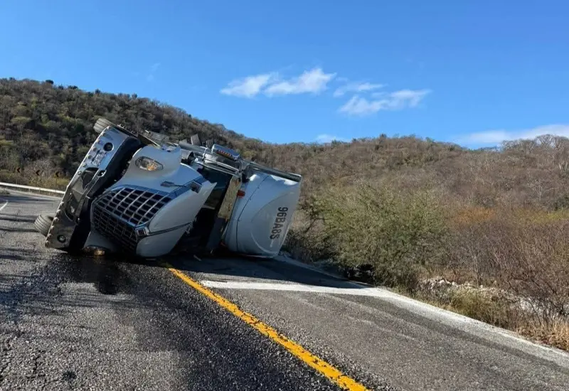 Un tractocamión volcado a un costado de la carretera tras el fatal accidente en el que el conductor perdió la vida.