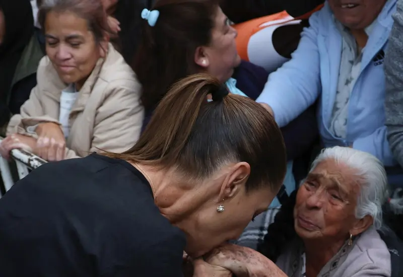 Claudia Sheinbaum entrega una tarjeta de la Pensión para el Bienestar a una persona adulta mayor en un evento en el Estado de México.