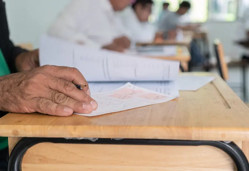 Un grupo de adultos en un salón de clases en Oaxaca participando en un programa educativo para el que se buscan voluntarios.
