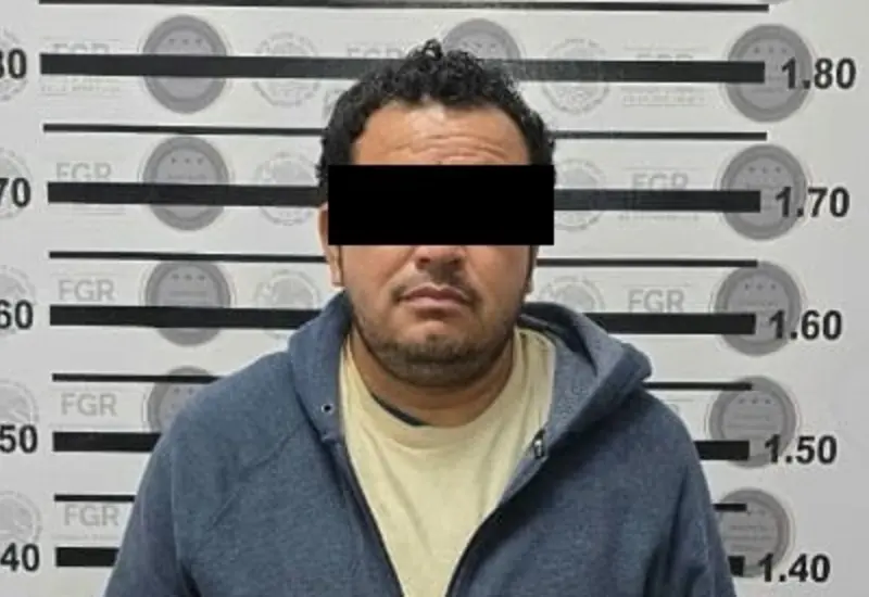 El presunto homicida E. M.S. es entregado por autoridades en Tijuana a elementos de la policía de Oaxaca, quienes lo escoltan.