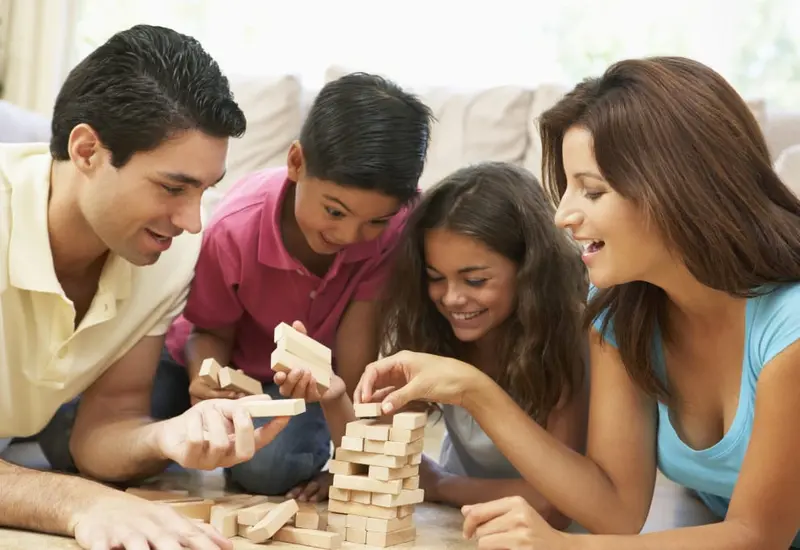 Una familia comparte un momento de convivencia y diálogo, ilustrando la importancia de dedicar tiempo de calidad entre padres e hijos.