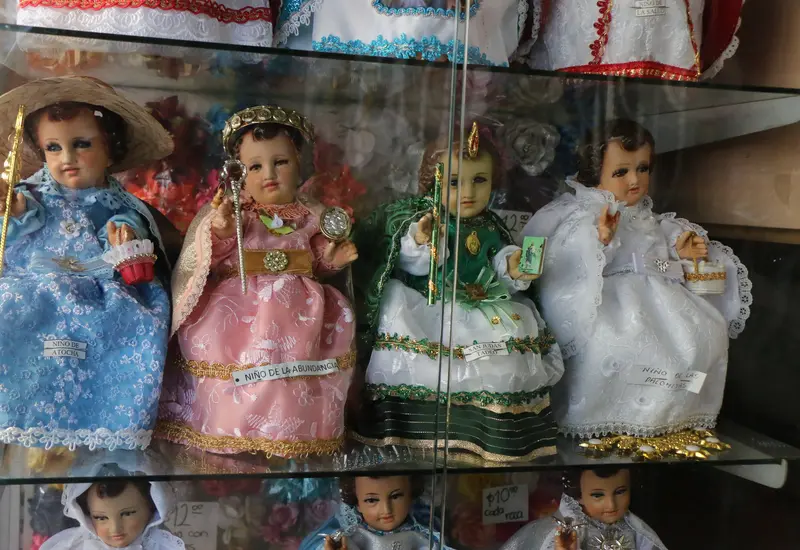 Una figura del Niño Dios es vestida por una familia para llevarla al templo y celebrar la misa del Día de la Candelaria.