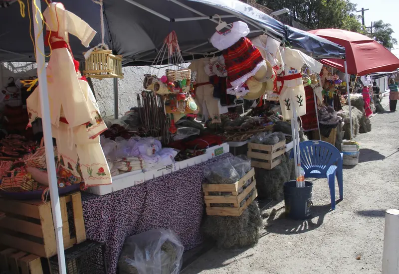 Vendedores en un mercado de Tehuantepec exhiben vestimentas tradicionales de diversos modelos para la celebración del Día de la Candelaria.