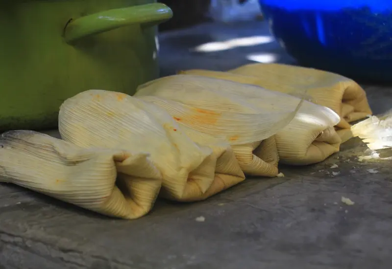 Una variedad de tamales tradicionales oaxaqueños exhibidos para la venta, reflejando el alza de precios de hasta 19% debido a la inflación.
