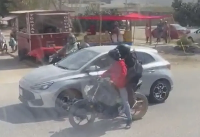 Dos sujetos a bordo de motocicletas asaltan violentamente a una mujer en una calle de Oaxaca, amenazándola con un arma de fuego.
