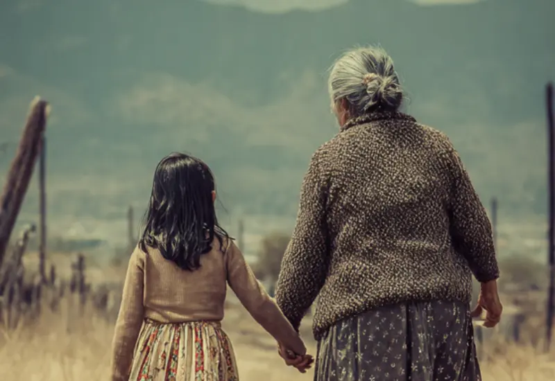 Una bisabuela tejiendo, representando la herencia y la lección de resiliencia sobre cómo curar el cansancio descansando con una labor, sin rendirse.
