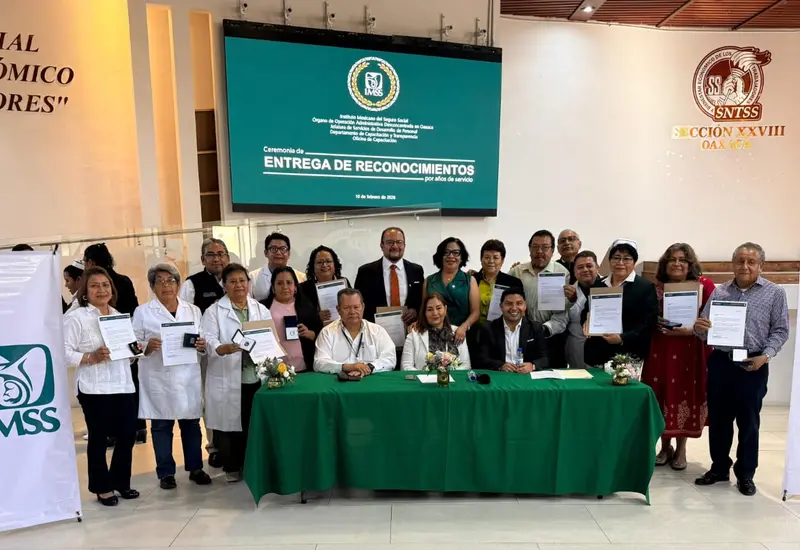 Autoridades del IMSS entregan distintivos a trabajadores en un evento para reconocer su trayectoria y compromiso con la institución.