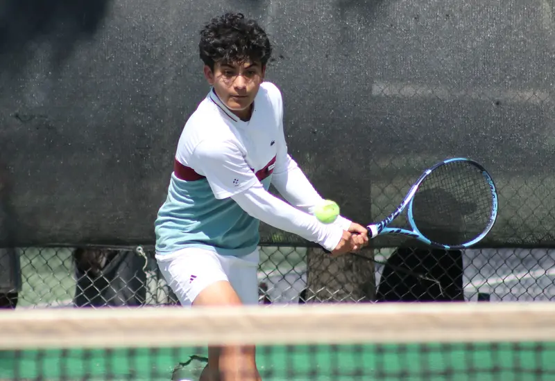 Un tenista en plena acción durante el Torneo Regional de Oaxaca, concentrado mientras se prepara para ejecutar su mejor golpe en la cancha.