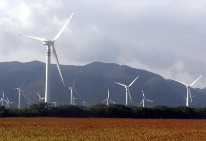 Imagen ilustrativa de turbinas eólicas y paneles solares que representan la inversión en proyectos para generar más energías limpias en México.