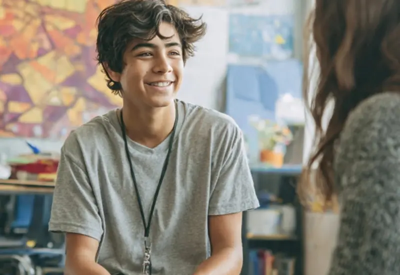 Un psicólogo ofrece escucha psicoanalítica a un estudiante de secundaria en un entorno escolar, ilustrando la atención a la salud mental en un internado.