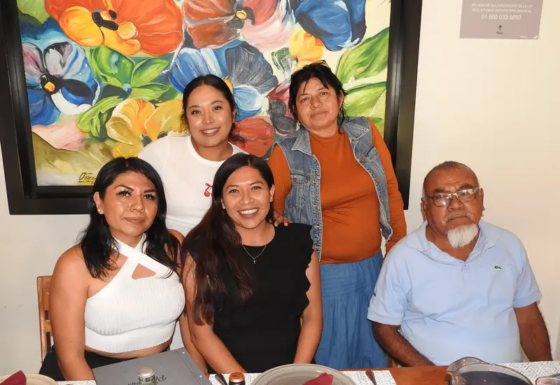 La familia Quiroz Cabrera posa sonriente para una foto durante la celebración de un momento muy especial, compartiendo su felicidad.