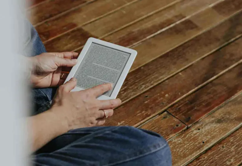 Una persona leyendo durante horas en un dispositivo digital sin pausas, lo que puede causar síntomas de fatiga ocular y riesgo para los ojos.