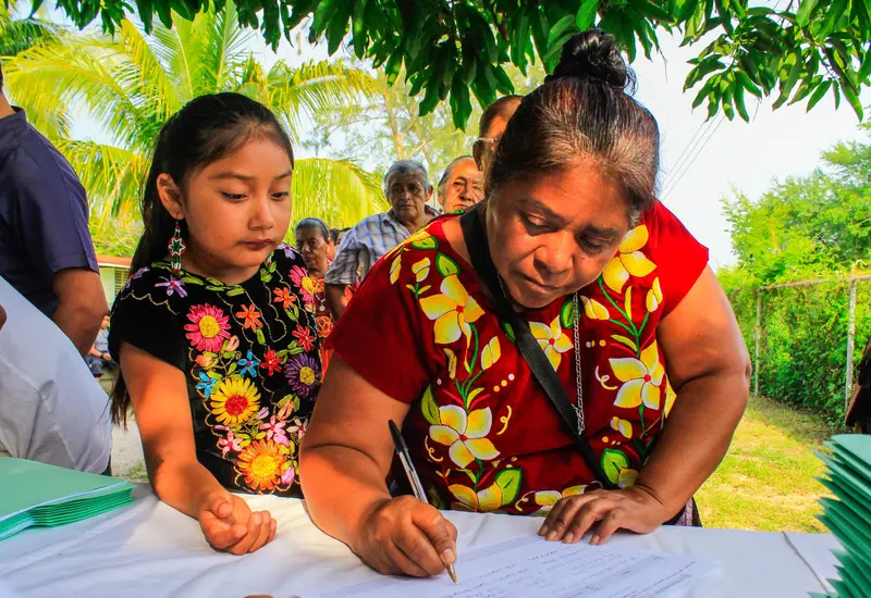 La indígena chinanteca de Tuxtepec, Imelda Conde Hernández, sostiene el reconocimiento que le fue entregado por su trayectoria y labor comunitaria.