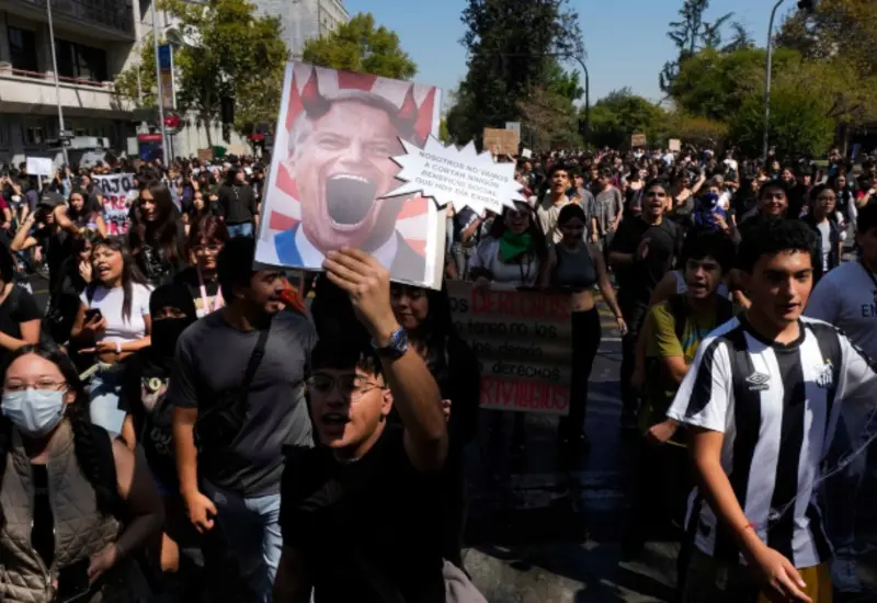 Jóvenes estudiantes protestan en las calles de Chile con pancartas en contra de los recortes a la educación gratuita propuestos por el gobierno.